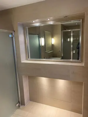 a bathroom with a large mirror and a sink at Perfect In The Park in Glasgow