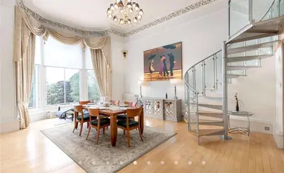 a dining room with a table and a staircase at Perfect In The Park in Glasgow