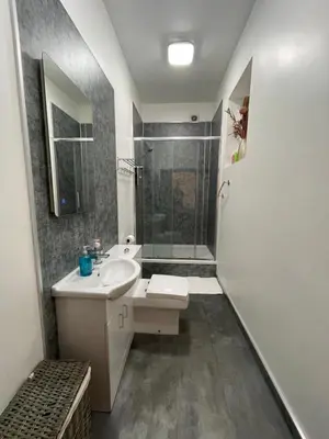a white bathroom with a sink and a shower at Premier Apartment C in Broxburn