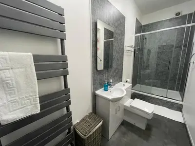 a white bathroom with a sink and a toilet at Premier Apartment C in Broxburn