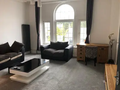 a living room with a couch and a coffee table at Premier Apartment C in Broxburn