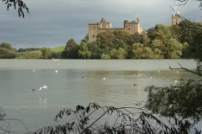 a castle sitting on top of a lake with birds at Sunny House with views to Edinburgh Skyline in Edinburgh