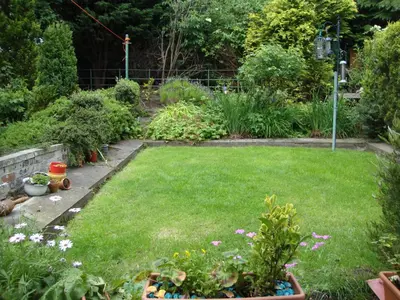 a garden with a lawn with flowers and plants at Sunny House with views to Edinburgh Skyline in Edinburgh