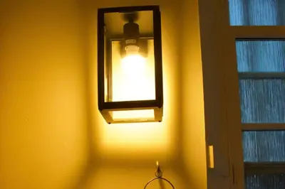 a light on a yellow wall with a window at The Old Jail Apartment, Inveraray in Inveraray