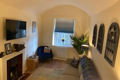 a living room with a couch and a window at The Old Jail Apartment, Inveraray in Inveraray