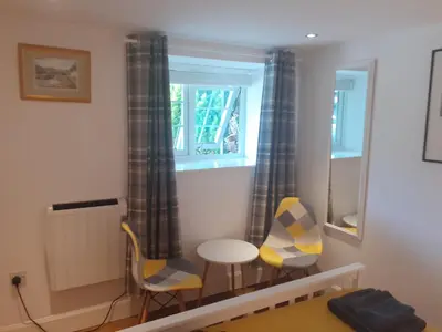 a room with two chairs and a table and a window at THE BOTHY SUITE BY TEMPLE WOOD in Lochgilphead