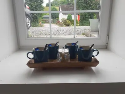 a shelf with four blue cups on a window sill at THE BOTHY SUITE BY TEMPLE WOOD in Lochgilphead