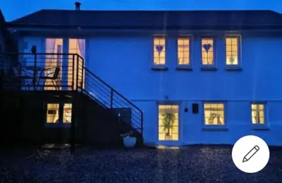 a blue building with lights in the windows at THE BOTHY SUITE BY TEMPLE WOOD in Lochgilphead