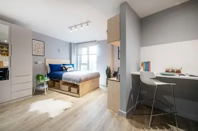 a bedroom with a bed and a desk and a kitchen at Silk Mill Edinburgh in Edinburgh