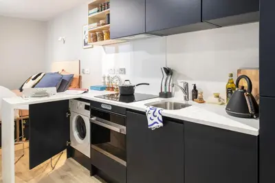 a kitchen with a sink and a washing machine at Silk Mill Edinburgh in Edinburgh