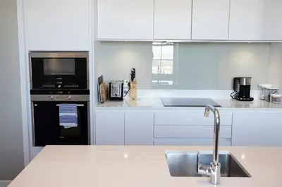 a white kitchen with a sink and a microwave at JOIVY Splendid Apartment in New Town in Edinburgh