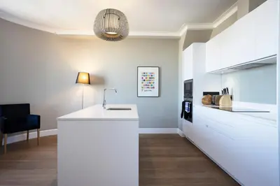 a kitchen with a white counter and a black chair at JOIVY Splendid Apartment in New Town in Edinburgh