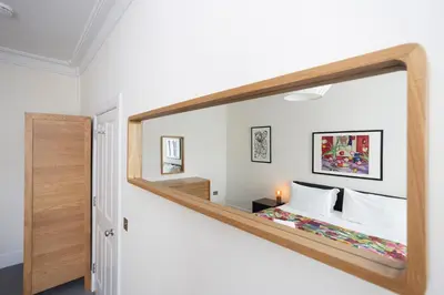 a large mirror in a room with a bed at JOIVY Splendid Apartment in New Town in Edinburgh