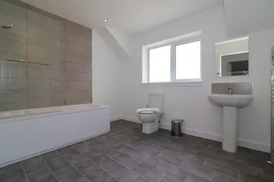 a bathroom with a toilet and a sink and a tub at Signature - Railway House 5 bed in Maryhill