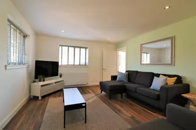 a living room with a couch and a tv at Signature - Railway House 5 bed in Maryhill