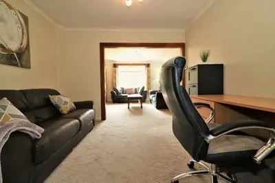a living room with a leather couch and a desk at Signature - Dumbreck House in Glasgow