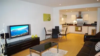 a living room with a couch and a tv and a table at Dreamhouse at Oswald Street, City Centre in Glasgow