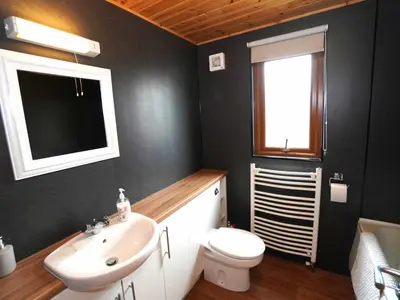 a bathroom with a sink and a toilet and a window at Chalet Loch Leven Lodge 11 by Interhome in Kinross