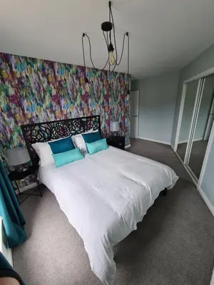a bedroom with a large bed with a colorful wall at EDEN Apartment, Oban in Oban