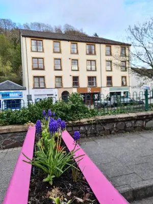 a pink garden with purple flowers in front of a building at EDEN Apartment, Oban in Oban