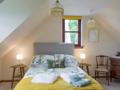 a bedroom with a bed with towels on it at Cluniter Cottage in Innellan