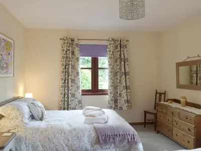 a bedroom with a bed and a window and a sink at Cluniter Cottage in Innellan