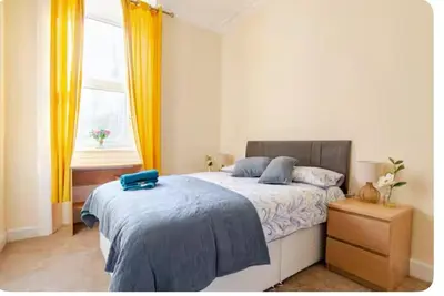 a bedroom with a bed with a blue pillow on it at 3 Bed Central Apartment - Pet Friendly & Parking in Edinburgh