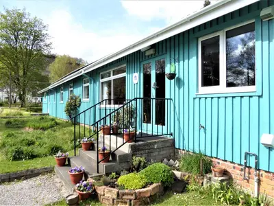 a blue house with some plants in front of it at Inveraray Hostel in Inveraray