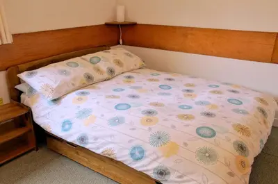 a bedroom with a bed with a wooden head board at Inveraray Hostel in Inveraray