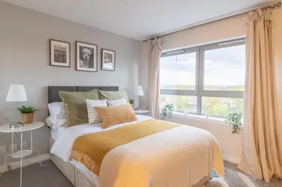 a bedroom with a bed and a large window at Luxury Riverview City Centre Apartment in Glasgow