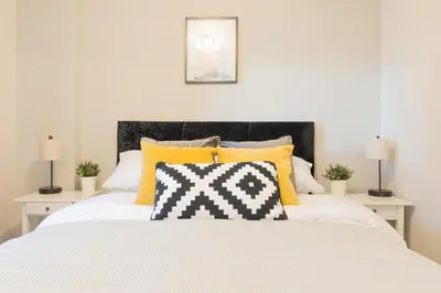 a bedroom with a large white bed with yellow pillows at Luxury Riverview City Centre Apartment in Glasgow