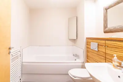 a bathroom with a tub and a toilet and a sink at Luxury Riverview City Centre Apartment in Glasgow
