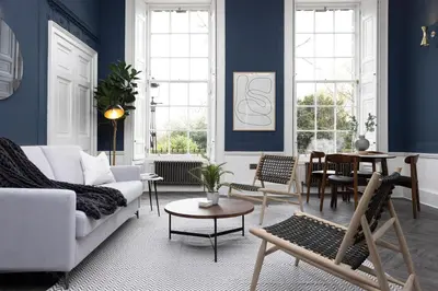 a living room with blue walls and a white couch at 29 Queen Street Aparthotel in Edinburgh