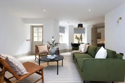 a living room with a green couch and a table at 29 Queen Street Aparthotel in Edinburgh