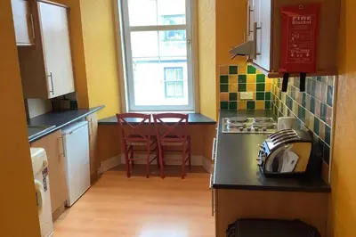 a kitchen with two stools and a counter top at Ferry View in Largs