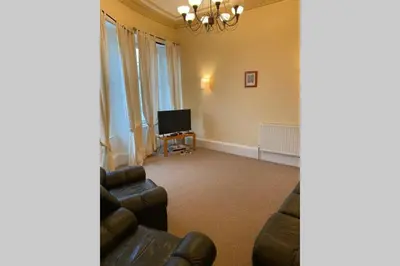 a living room with a couch and a television at Ferry View in Largs