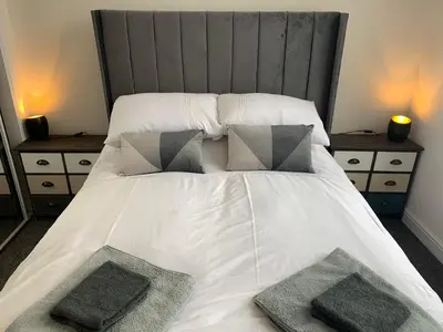 a bed with two pillows on it with two night stands at Ayr Cozy Corner Apartment in Ayr