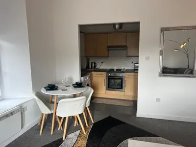 a kitchen with a table and chairs in a room at Ayr Cozy Corner Apartment in Ayr