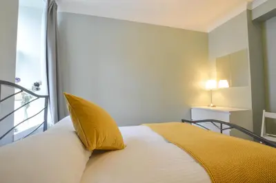 a bedroom with a bed with a yellow pillow at McCaig's Way in Oban
