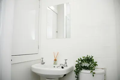 a white bathroom with a sink and a mirror at McCaig's Way in Oban