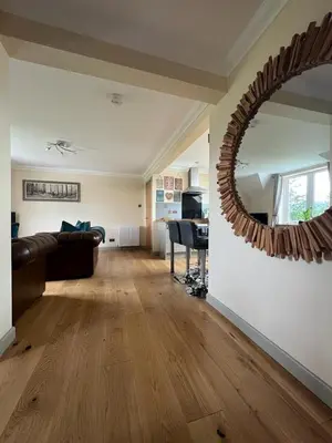 a living room with a couch and a mirror at Taigh Mara(Marine House) 2 bed Apartment in Fort William