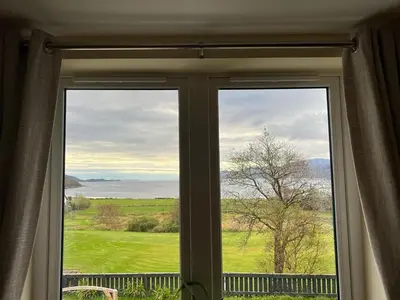 a window with a view of a green field at Taigh Mara(Marine House) 2 bed Apartment in Fort William