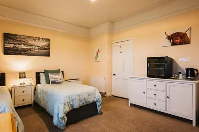 a bedroom with a bed and a television in it at Eilidh’s Guest House in Port Ellen