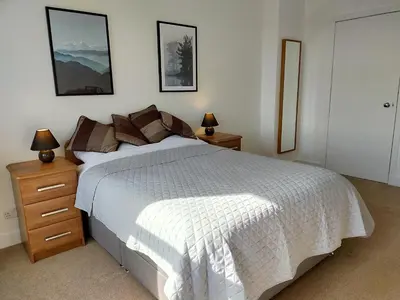 a bedroom with a white bed with two night stands and two lamps at Buckieburn - self-catering - rural in Stirling