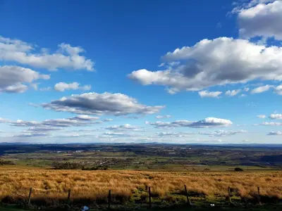 a field of grass with a blue sky and clouds at Buckieburn - self-catering - rural in Stirling