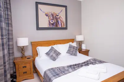 a bedroom with a bed with a picture of a cow at Braeside Guest House, Loch Lomond in Drymen