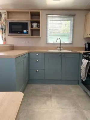 a kitchen with blue cabinets and a sink at The Roecliffe 54 in Dunoon