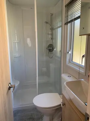 a bathroom with a shower and a toilet and a sink at The Roecliffe 54 in Dunoon