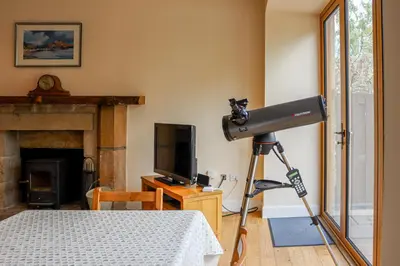 a camera on a tripod in a room with a bed at Fantastic Cottage in Loch Lomond National Park in Alexandria