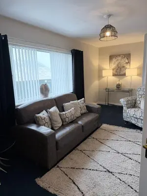a living room with a couch and a large window at No 19 Serviced Apartment in Ayr